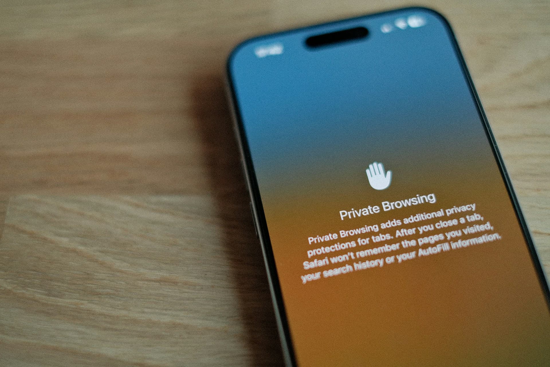 A phone on a wooden table showing a private browsing screen